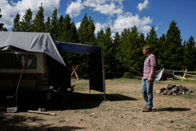 A man approaches a homeless camp at a park in Colorado.