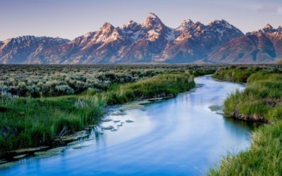 The Snake River flows beneath the looming peaks of the Teton Range in Grand Teton National Park.