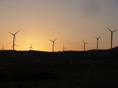 The sun behind wind turbines