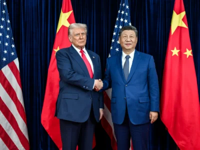 The presidents of the US and China standing on a stage and shaking hands with flags behind them