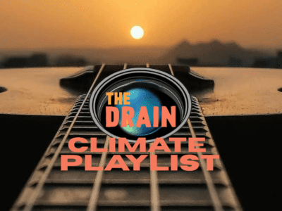A close-up of a guitar neck at sunset, with THE DRAIN inside a planet graphic, and CLIMATE PLAYLIST in bold letters layered over the image. The background shows a blurred landscape beneath a glowing sun.
