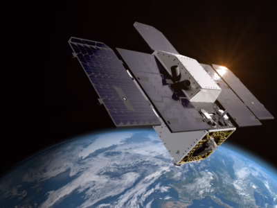 A Carbon Mapper satellite orbits above Earth with the sun shining in the background.